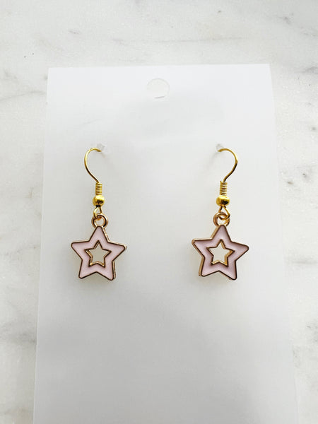 Star-shaped earrings on a white card with a marble background
