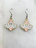 Pair of earrings with moth design on a marble  background