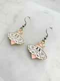 Pair of earrings with moth design on a marble  background
