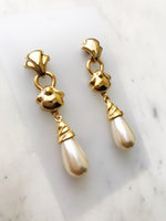 Look sharp with these sophisticated Vintage Gold Pearl Drop earrings! Crafted with an elegant gold finish, these earrings make a big impression. They'll give you that quintessential classic look, but with a unique twist. Go ahead, make a statement!  Gold Plated  60mm x 13mm