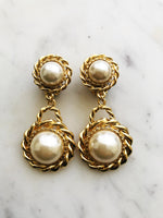 These Rope Double Pearl Earrings are a timeless treasure! Classy and chic, they feature vintage pearl cabochons that will elevate any look. So, put yourself in pearls of wisdom and add some pizzazz to your wardrobe.  Gold Plated  Clip On   65mm x 30mm