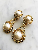 These Rope Double Pearl Earrings are a timeless treasure! Classy and chic, they feature vintage pearl cabochons that will elevate any look. So, put yourself in pearls of wisdom and add some pizzazz to your wardrobe.  Gold Plated  Clip On   65mm x 30mm